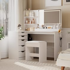 a white vanity with drawers and stools in a bedroom next to a large window