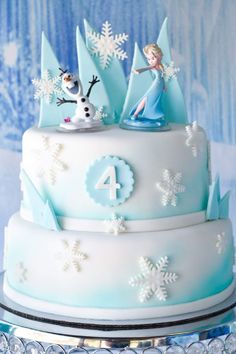 a birthday cake decorated with frosting and frozen princess figures