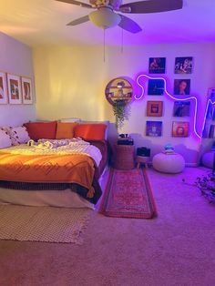 a bed room with a neatly made bed next to a ceiling fan and pictures on the wall