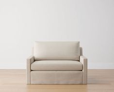 a white couch sitting on top of a hard wood floor next to a white wall