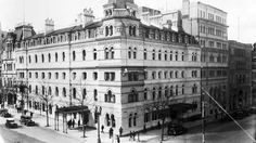 an old black and white photo of a large building on the corner of a street