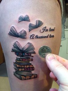 someone is showing off their tattoo with books on it