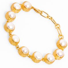 The Vintage Style Pearl Tennis Bracelet, a stunning blend of classic design and modern elegance. This bracelet features 24k gold-plated vintage-inspired settings, each housing a round pearl stone that creates a beautiful, seamless flow. Its timeless charm makes it the perfect accessory for weddings, special events, or to add a touch of elegance to your everyday outfits. The sophisticated design of this pearl tennis bracelet adds a delicate yet luxurious touch, making it a must-have for anyone who appreciates vintage glamour. Details Crafted with high-quality brass and plated with 24k gold for a luxurious finish. Pearl stones Bracelet size 7'' Avoid contact with chemicals, makeup, parfume. Do not use dips or abrasive cleaners on bracelet. To clean and brighten it up your bracelet, wipe them Elegant Pearl Chain Bracelet For Formal Occasions, Gold-tone Plated Bracelets For Formal Occasions, Formal Gold-tone Plated Bracelets, Formal Pearl Charm Chain Bracelet, Luxury Pearl Chain Bracelet For Formal Occasions, Luxury Pearl Drop Bracelet For Formal Occasions, Formal Gold Plated Bracelets, Classic Gold-plated Bracelet With Oyster Detail, Formal Gold Pearl Bracelet With Oyster Design