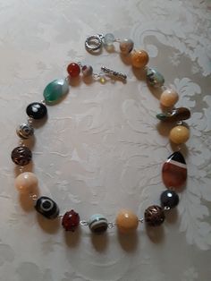 A beautiful assorted gemstone necklace chain linked. Assorted beads are sandstone, carnelian, onyx, jasper, turquoise and other assorted beads. These beautiful beads measure from.12mmm to 18mm.the flat beads measure 35mm by 24mm. A great look for any occasion. Multicolor Agate Large Beaded Necklaces, Multicolor Agate Beaded Necklace With Large Beads, Carnelian Jewelry With Colorful Beads For Jewelry Making, Multicolor Carnelian Jewelry With Polished Beads, Multicolor Large Beads Agate Necklace, Multicolor Carnelian Beaded Jewelry, Adjustable Multicolor Agate Necklace, Multicolor Carnelian Necklaces With Polished Beads, Multicolor Agate Necklaces With Large Beads