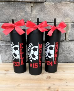 three black tumblers with red bows are sitting next to each other on a table