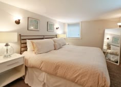 a bed sitting in a bedroom next to a dresser and mirror on top of a wall