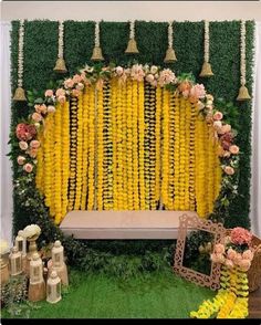 an arrangement of yellow flowers and greenery on display