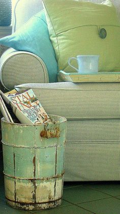 an old bucket is sitting on the floor next to a couch