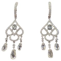 Embrace the timeless elegance of yesteryears with these stunning antique dangle earrings, meticulously crafted in lustrous 18 karat white gold. At the heart of each earring lies a shimmering rose cut diamond, weighing a collective 0.2 carats. Known for its vintage charm and romantic facets, the rose cut diamond gracefully anchors the design. Suspended beneath, a trio of dazzling briolette diamonds dances with every movement, their combined weight totaling 2.41 carats. Encircling the rose cut and Luxury Diamond Drop Earrings, Luxury Drop Diamond Earrings, Luxury White Gold Pierced Bridal Earrings, Elegant Drop Earrings With Diamond Cut, Luxury Teardrop Chandelier Earrings With Brilliant Cut, Elegant White Gold Dangle Diamond Earrings, White Gold Diamond Earrings With Rose Cut For Evening, Exquisite Drop Diamond Earrings, Exquisite Pierced Diamond Earrings For Formal Occasions