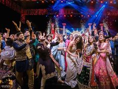 a group of people standing on top of a stage with their hands in the air