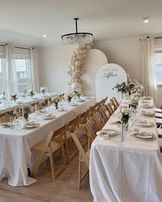 a long table with white linens and place settings