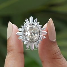 Old Mine Cushion Moissanite Ring. This Colorless Moissanite Bridal Ring features a dazzling Cluster Set Halo design that radiates elegance and beauty. The Star Burst Wedding Ring adds a touch of sparkle and sophistication to your ensemble. 𝐉𝐞𝐰𝐞𝐥𝐫𝐲 𝐕𝐢𝐝𝐞𝐨: https://youtu.be/iaOMz6ZDM8w ✥ 𝐌𝐚𝐢𝐧 𝐒𝐭𝐨𝐧𝐞 𝐃𝐞𝐭𝐚𝐢𝐥𝐬: ↣ Shape: old mine cushion ↣ Type: Moissanite ↣ Weight: 5.30 CT (App.) ↣ Color/Clarity: Colorless / VVS ↣ Making Process: Handmade - Crafted by our experienced team ✥ Halo Moissanite Engagement Ring, Moissanite Halo Ring, Jewelry Video, Moissanite Engagement Ring Halo, Star Burst, Ring Cluster, Cushion Cut Moissanite, Halo Design, Ring Moissanite