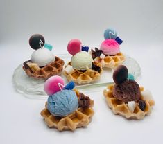 four waffles with ice cream and toppings on them