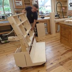 a man working in a woodworking shop with cabinets and drawers on the counter top