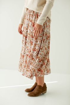 Feminine, and crafted out of a beautiful floral fabric, the 'Meredith' Floral Print Button Detail Midi Skirt is the perfect transitional piece. The midi length makes it easy to wear in any season, and in so many ways! The skirt is fully lined, has button details on the front, and an elastic waistband. Pair it with boots and a sweater, or a simple top and sandals in the warmer months! 100% Polyester Fully Lined Hand Wash Cold Hang or Lay Flat to Dry Do Not Bleach Iron Low Heat if Needed Model Hei Raglan Sleeve Sweater, Simple Top, Layered Tops, Rolled Hem, Skirt Leggings, Holiday Collection, Blouse Dress, Floral Fabric, Tops For Leggings