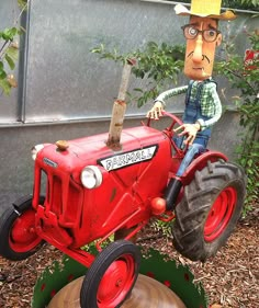 a statue of a farmer on a red tractor