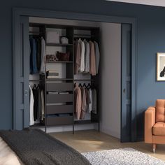 an open closet with clothes on hangers and a couch in the corner next to it