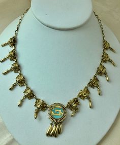 A rare vintage 1960's Mexican sterling gold plated "Mayan"necklace . The necklace consists of 12 Mayan Masks with a central traditional tribal motif set with turquoise. The necklace measures 16 inches long.The craftsman ship is very good and the details well executed. Even the clasp is decorated with a stylized tribal motif. The necklace weighs 26 grams. Traditional Gold Necklaces With Vintage Charm, Traditional Gold Necklace With Vintage Charm, Gold Turquoise Necklace Costume Jewelry For Gift, Gold Turquoise Costume Jewelry Necklace For Gift, Southwestern Style Gold Necklace For Gift, Maya Necklace, Mayan Necklace, Mayan Earrings, Vintage Native American Jewelry Gold