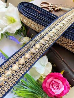 a pair of blue belts sitting on top of a table next to flowers