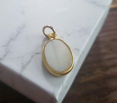 oval shaped mother of pearl with gold frame.  4mm jump ring pendant size 20x11mm White Oval Pearl Pendant Jewelry, Classic White Oval Pendant Jewelry, Elegant Oval White Jewelry With Mother Of Pearl, Elegant White Oval Mother Of Pearl Jewelry, White Cabochon Mother Of Pearl Jewelry, White Cabochon Oval Pendant Jewelry, White Pearl Charm Jewelry, White Oval Jewelry With Pearl Charm, White Mother Of Pearl Cabochon Jewelry