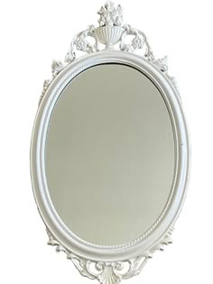 an ornate white framed mirror on a wall