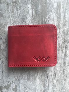 100 % full-grain handmade leather wallet. Slim and small red bifold wallet. Precisely made from high quality cow leather. Lasts for years, therefore is a perfect gift. The wallet is engraved with an ancient stylized grass-snake sign. Wallet is made from full grain cow leather. Crazy horse is a specially processed leather type that gives it an antique appearance. This type of leather is long lasting, very durable and any scratches or rubs turn it to a different shade, bend line also fades to a di Red Bifold Wallet For Everyday Use, Red Leather Wallet With Card Slots, Red Leather Trifold Wallet For Daily Use, Red Leather Trifold Wallet For Everyday, Red Leather Trifold Rectangular Wallet, Handmade Red Wallet For Everyday Use, Handmade Red Wallet, Red Trifold Wallet For Daily Use, Red Bifold Wallet With Rfid Blocking