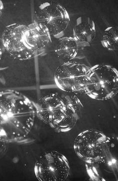 many bubbles floating in the air near each other on a black and white background,