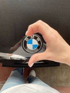 someone is holding the emblem on their bmw car