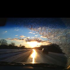 the sun is setting on an icy road