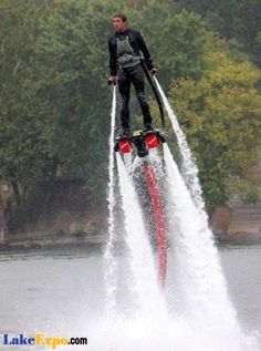 a man riding water skis while being pulled by a boat in the water with trees behind him