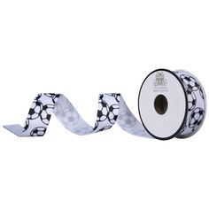 a roll of white and black ribbon with soccer balls on the side, in front of a