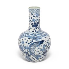 a blue and white vase with fish on it's side, against a white background