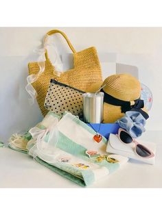 a pile of items sitting on top of a white table next to a bag and sunglasses