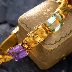 This colorful fancy link bracelet is accented with one (1) natural amethyst, two (2) natural citrine, one (1) natural aquamarine, one (1) natural green tourmaline and one (1) natural prasiolite set into four-prong settings. The gold links have a brushed finish that plays with the light beautifully. The bracelet fits p to a 6.75 inch wrist and is finished with a hidden box clasp and figure eight safety. Luxury Yellow Gold Multi-stone Bracelet, Modern Gold Multi-stone Gemstones, Luxury Yellow Gold Multi-stone Bracelets, Luxury Gemstone Accented Bracelet Jewelry, Yellow Gold Gemstone Accented Bracelet, Elegant Multi-stone Bracelet Jewelry, Yellow Gold Bracelet With Gemstone Accents, Elegant Multi-stone Bracelet, Luxury Amethyst Multi-stone Jewelry