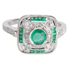 an emerald and diamond ring with white diamonds on the sides, set in 18k white gold