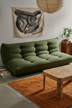 a living room filled with furniture and a painting hanging on the wall above an area rug