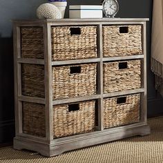 an old dresser with wicker baskets and a clock on top