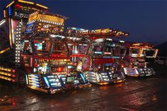 several brightly lit trucks parked next to each other