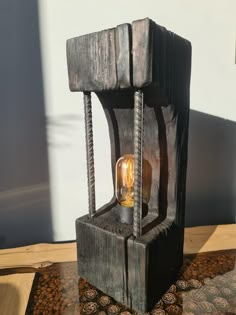 an old wooden lantern with a light bulb on top of it sitting on a rug