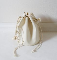 a white drawstring bag sitting on top of a table next to a wall