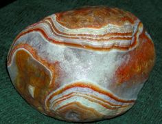 a large rock sitting on top of a green surface