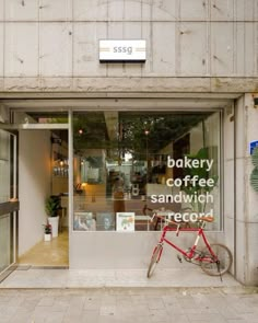 a red bike parked in front of a bakery