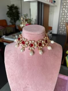 Elevate your style with our exquisite Kundan choker necklace set. Handcrafted from premium brass, this one-of-a-kind masterpiece boasts intricate Kundan work, adorned with dazzling red stones and lustrous pearls. Its premium quality and regal design make it the perfect accessory for special occasions, exuding timeless beauty and sophistication. Make a statement with this elegant ensemble. Dimensions Weight of choker is 70 g. Choker comes with adjustable Dori. Weight of earrings is 16 g per pair. Heavy Red Choker For Wedding, Chocker Neckless, Red Kundan Choker Necklace For Wedding, Red Kundan Choker With Stone Work, Bollywood Style Red Kundan Choker Necklace, Traditional Red Choker Jewelry Set, Hand Jewelry Rings, Diamond Pendants Designs, Vintage Wedding Jewelry