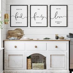 three framed art prints on the wall above a white buffet with drawers and cupboards