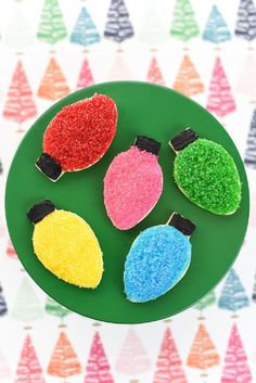 four decorated cookies sitting on top of a green plate