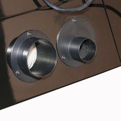 two metal knobs are attached to the side of a brown and black wall mounted speaker