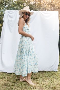 The Saylor Midi Dress features a v neckline, adjustable back tie straps, a tiered skirt and a lining. 100% Cotton Hand Wash Cold, Hang to Dry Flowy V-neck Sundress With Tie Straps, Blue Maxi Dress With Tie Straps For Garden Party, Tiered Maxi Dress With Tie Straps For Spring, Spring Midi Dress With Tie Straps And Tiered Design, Spring Midi Dress With Tie Straps And Tiered Shape, Spring Tiered Maxi Dress With Tie Straps, Spring Tiered Midi Dress With Tie Straps, Spring Dresses With Knotted And Ruffled Straps, Breezy Sundress With Adjustable Straps For Brunch