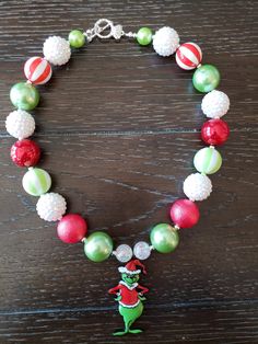 "How The Grinch Stole Christmas Inspired Children's Chunky Bubblegum Bead Necklace & Bracelet Set/ Holidays This very cute Christmas Grinch Necklace & Bracelet Set is a perfect addition to any holiday outfit and the holiday season. The Necklace is made up primarily of 20mm beads in shades of red, green and white. The necklace measures approximately 11\" when toggled around neck including the Grinch pendant. The Bracelet is an elastic bracelet, doubled up for extra strength. The Necklace Christmas Party Beaded Necklaces With Round Beads, Christmas Party Round Bead Necklaces, Festive Christmas Beads With Round Shape, Festive Christmas Beads, Christmas Festive Round Beads, Christmas Holiday Necklace With Round Beads, Christmas Gift Beaded Necklaces With Round Beads, Cute Handmade Christmas Jewelry, Cute Handmade Jewelry For Christmas