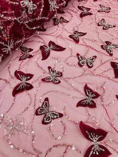 pink and red embroidered fabric with butterfly appliqued on the side, along with beaded sequins