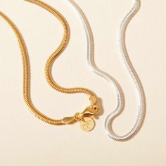 Embrace the elegance of our Snake Chain Necklace, a staple piece to add sophistication to every look. Perfect for wearing alone or for layering alongside your favourite Merci Maman personalized necklaces, this chain is a timeless way to elevate your everyday jewelry collection.&nbsp;18K Champagne Gold Plated or 925 Sterling SilverLength: 0.4Width: 0.09Thickness: 0.05Sent with love in a complimentary gift box Minimalist Sterling Silver Necklace With Gold Chain, Classic Silver Chain Necklace With Initial Pendant, Classic Silver Initial Pendant Chain Necklace, Dainty Gold Chain Necklace With Round Pendant, White Gold Plated Adjustable Chain Necklace, Timeless Snake Chain Necklaces, Timeless Snake Chain Necklace, Classic Chain Necklace With Initial Pendant, Delicate Snake Chain Necklace For Layering